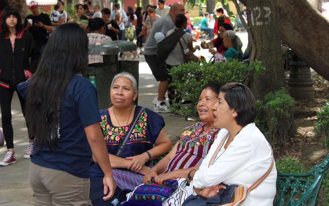 Older Mexican women talking with a young one, sitting on a bench at Jardín Centenario - Coyoacán, CDMX