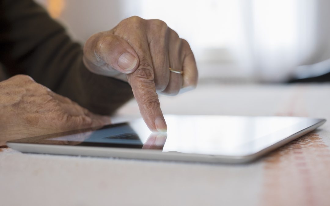 Senior Woman Using Tablet Computer At Home