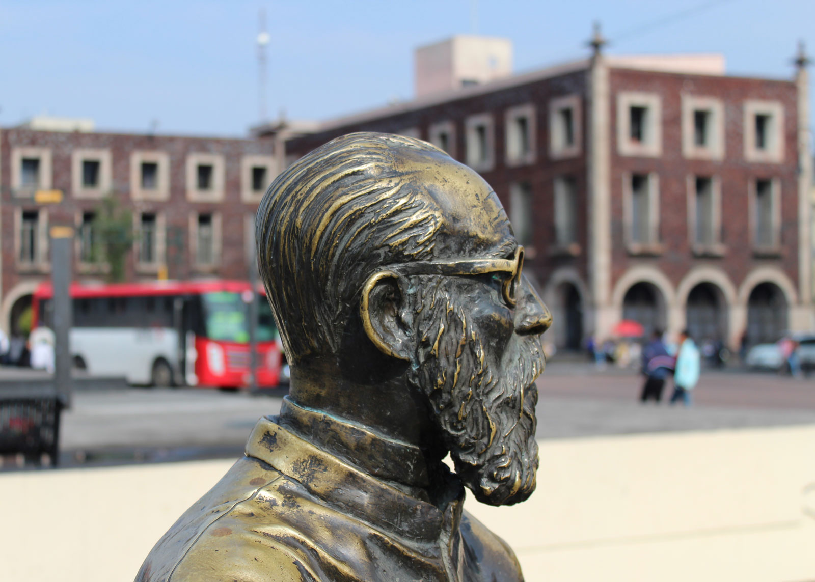 Bronze statue of old man by a bench in main square, Toluca, Mexico (August 2017)