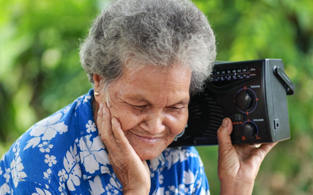 Old Woman Listening To Music With A Vintage Radio, outdoor