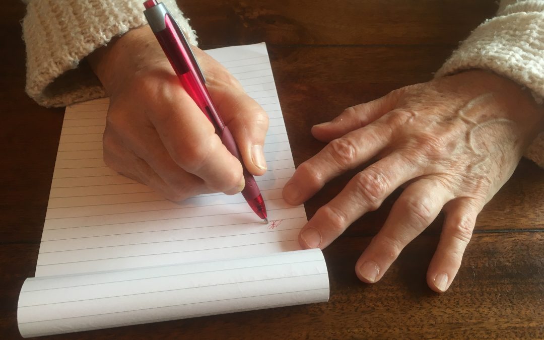 Woman with arthritis trying to write a letter